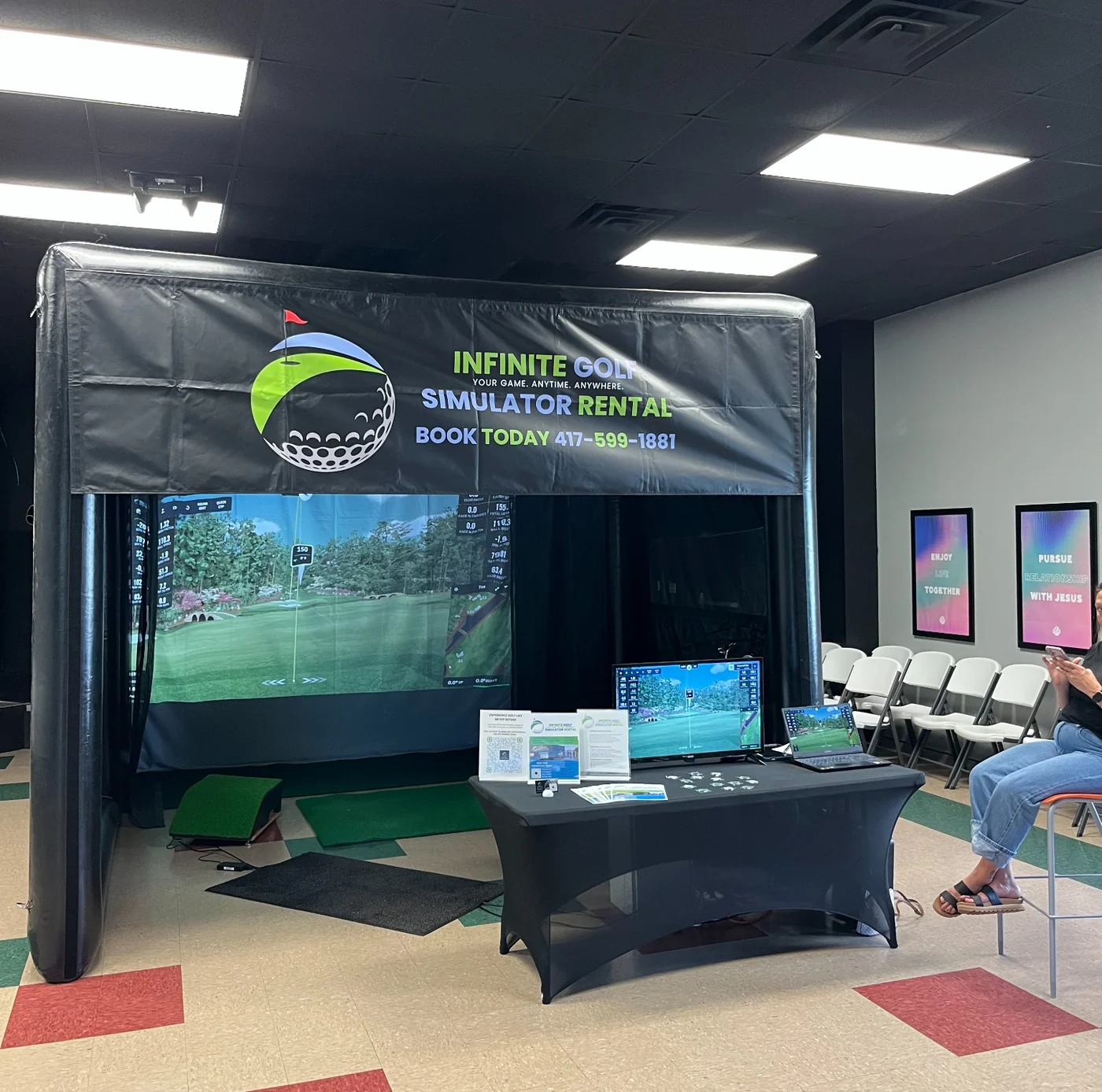 Infinite Golf simulator setup at an indoor event