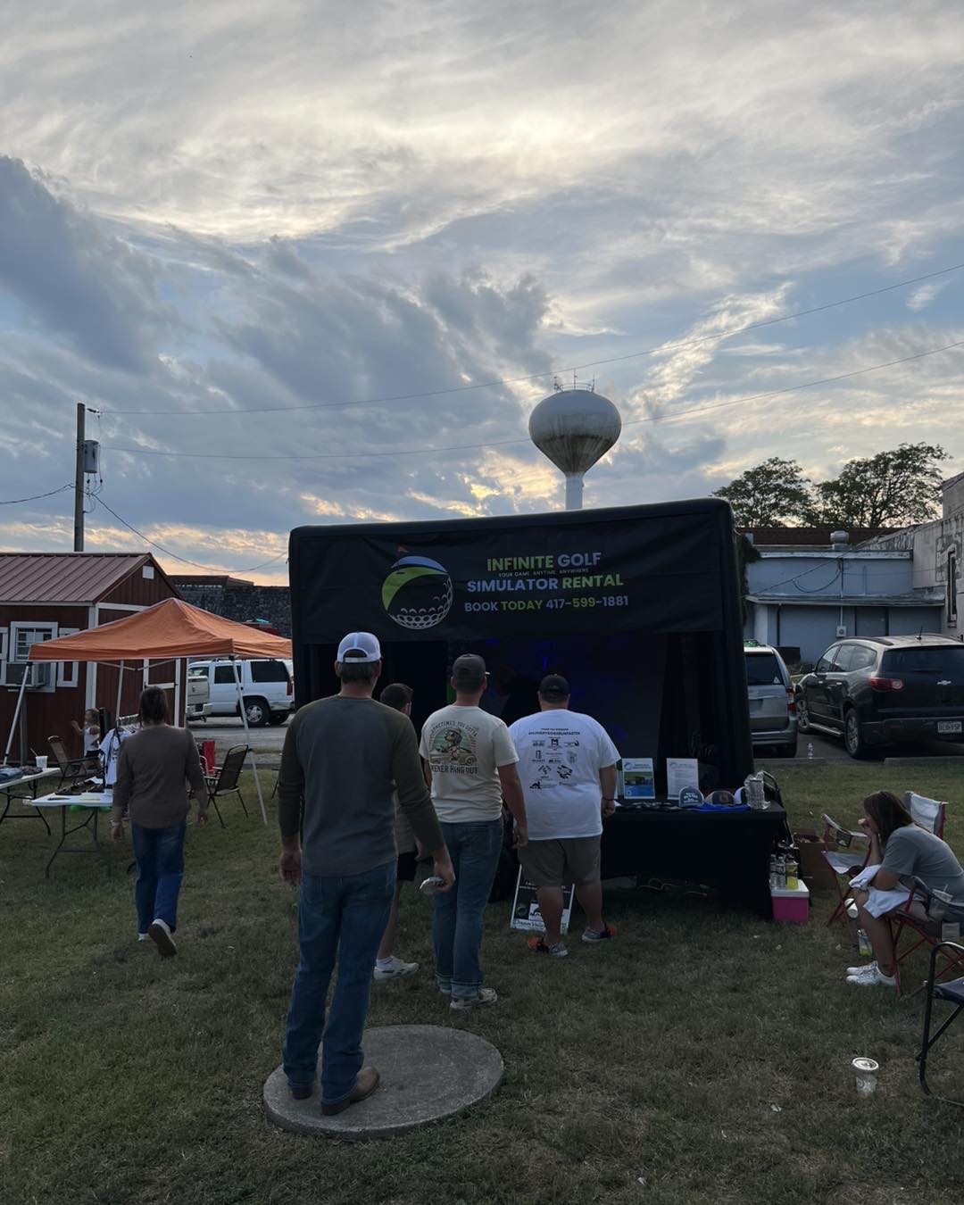 Guests gathering near the simulator during an outdoor event