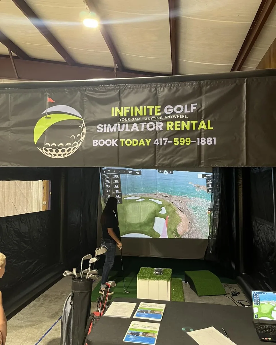 A guest playing inside the branded Infinite Golf simulator at the Bolivar Elks Family Event